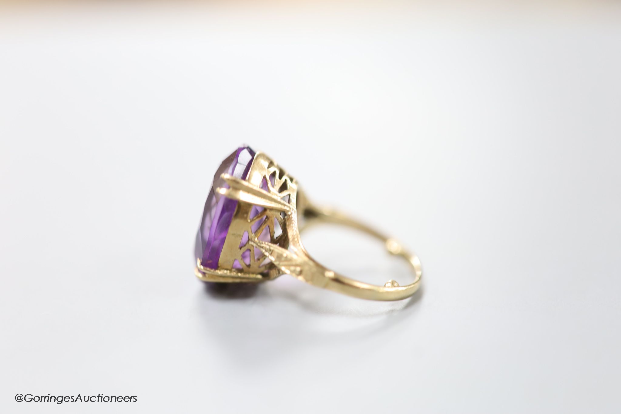 A 9ct gold and oval cut amethyst set dress ring, size H